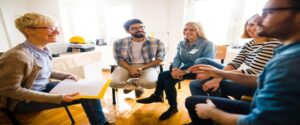 people sitting on chairs in a circle talking