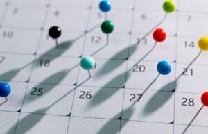 calendar with colored dot pins on dates to indicate organization