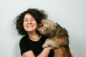happy owner holding cute little dog