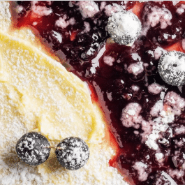 close up of crepes with lemon cream and blueberry sauce