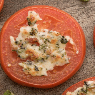 Broiled slice of tomato with cheese and herb topping.