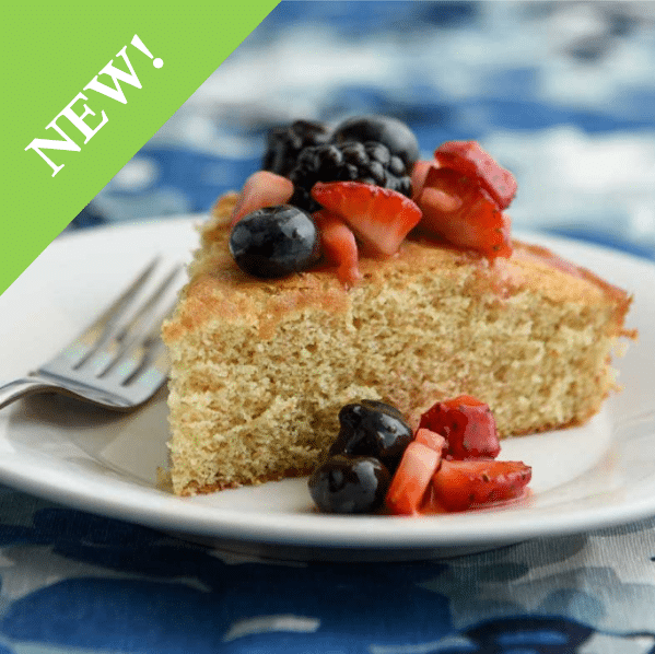 slice of sponge cake topped with cut strawberries, blueberries and blackberries