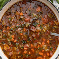 finely chopped vegetable soup in brown broth with ladel
