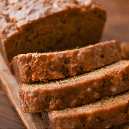 small loaf of broad bread sliced on a wooden cutting board