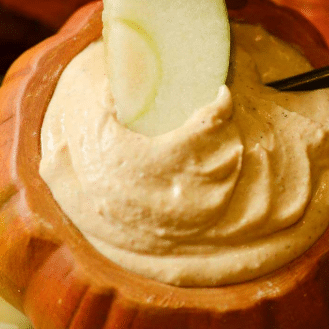 pumpkin dip in a mini pumpkin with apple garnish