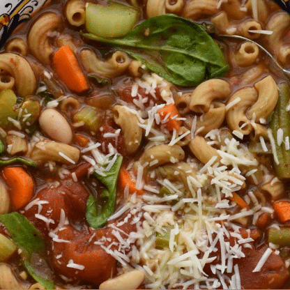 minestone soup topped with basil and cheese